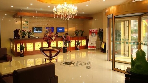 A hotel reception area with a chandelier, reception desk, seating area, and a glass door entrance. - Greentree Inn Dezhou Kangbo Avenue Statium Express Hotel (Dezhou)
