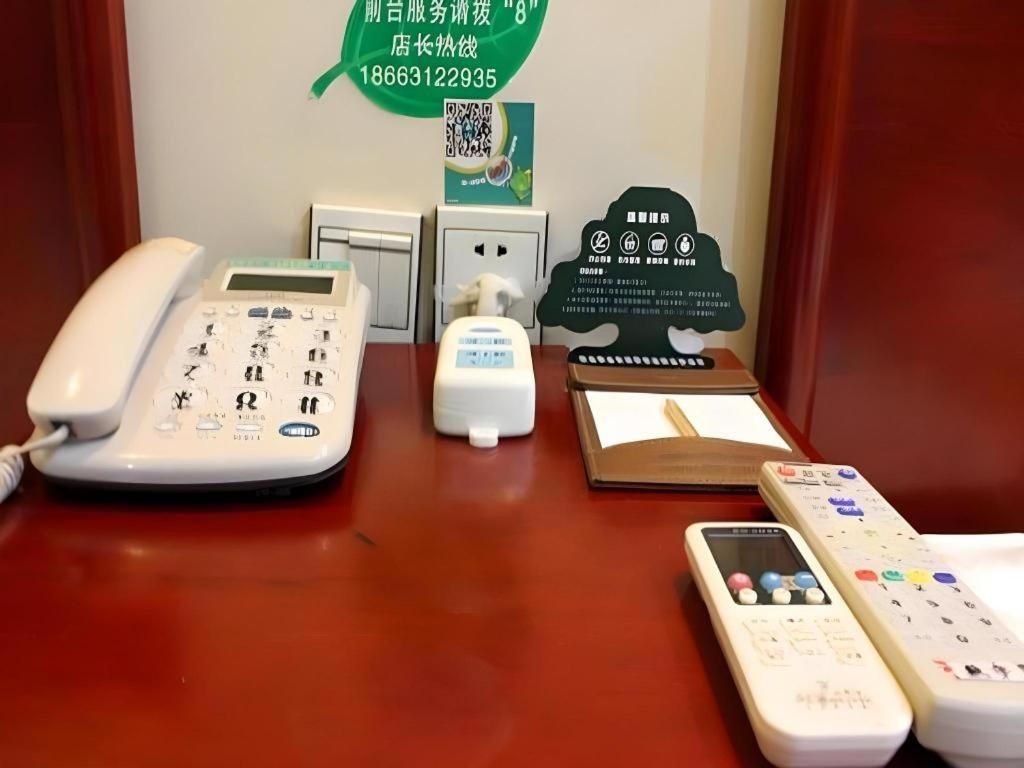 Ein Hotelrezeptionstresen mit Telefon, Taschentuchspender, Notizblock und Fernbedienung.