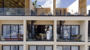 Un hotel de diseño moderno, con balcones que tienen asientos exteriores y fachada de vidrio.