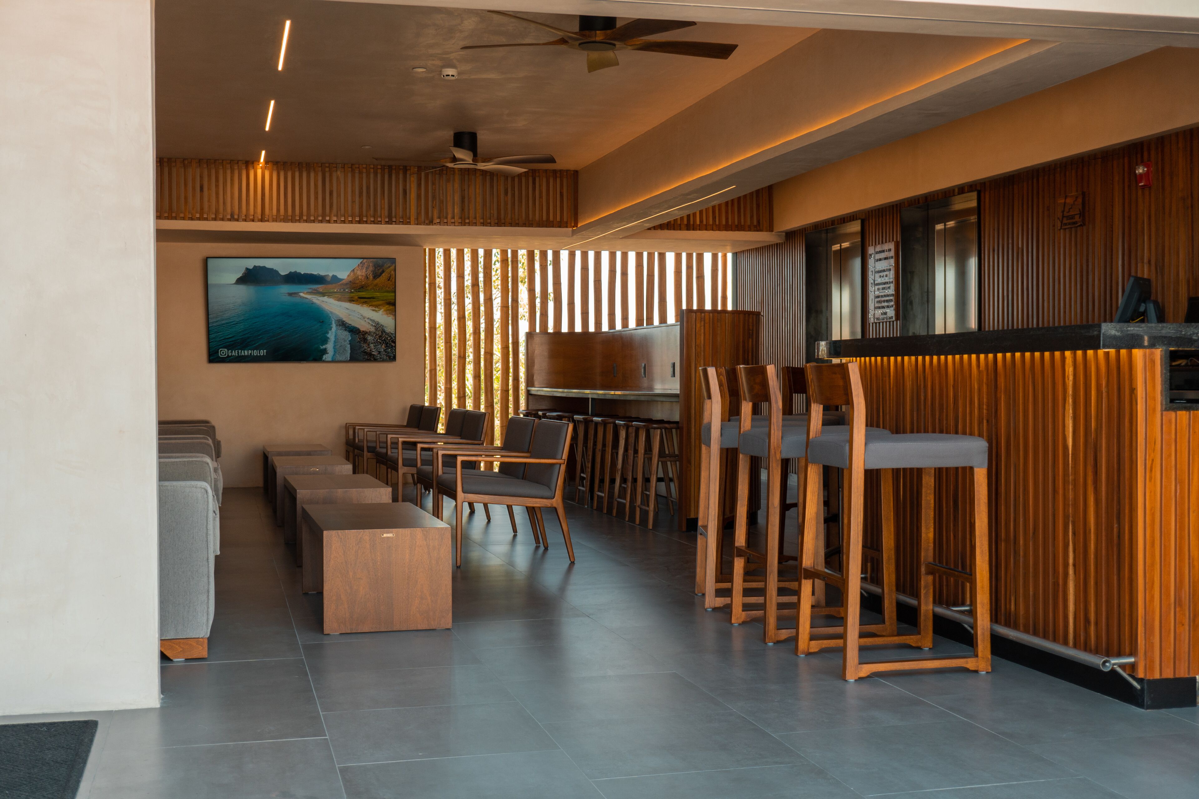 A modern interior with a bar area, seating, and a large wall-mounted TV.
