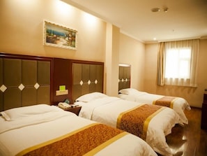 Habitación de hotel con tres camas, un cuadro en la pared y una ventana con cortinas.