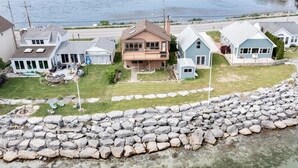 Zona residencial costera con casas, un litoral rocoso y una masa de agua.