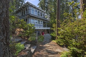A modern two-story house surrounded by dense forest. - Treasure Island Beach House w/ Kayaks, Fun, Views, and Hot Tub! (Allyn)