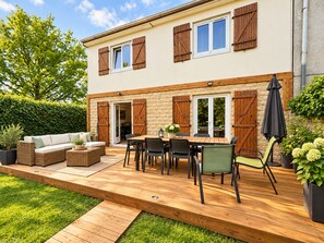 A two-story house with a patio area featuring a wooden deck, outdoor furniture, and a dining table. - The Leaning House with a Private Jacuzzi (Rosny-sous-Bois)