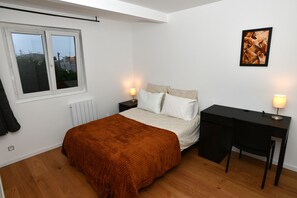 A bedroom with a bed, a desk, and a window. - The leaning house with private Jacuzzi (Rosny-sous-Bois)