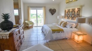 Een hotelkamer met een bed, een stoel, een dressoir en uitzicht op de omgeving.