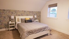 A bedroom with a bed, nightstands, a window, and a floral wallpaper. - 6 Bed 6 bath Country Red Brick Home (Eden)