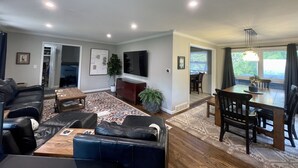 A spacious living room with a sofa, a coffee table, and a dining area with a table and chairs. - Updated in 2021 Notre Dame Football Weekend Entertaining Home (South Bend)