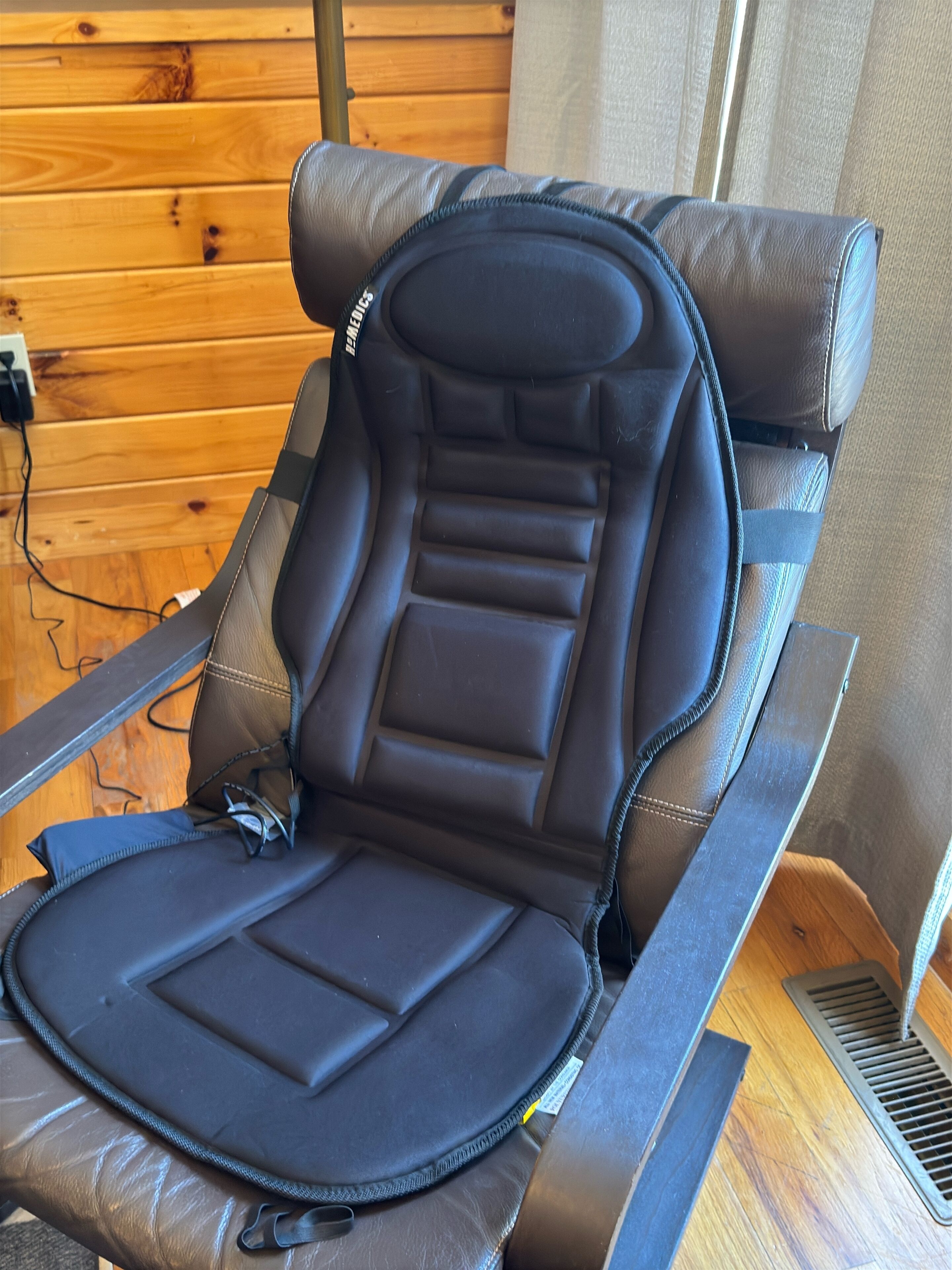 A brown leather chair with a headrest and a padded seat.
