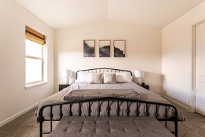 A bedroom with a bed, bedside tables, and wall art. - Contemporary 3 bedroom townhome in downtown Fruita (Fruita)