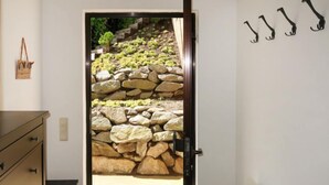 A doorway leading to a stone staircase with a view of greenery outside.