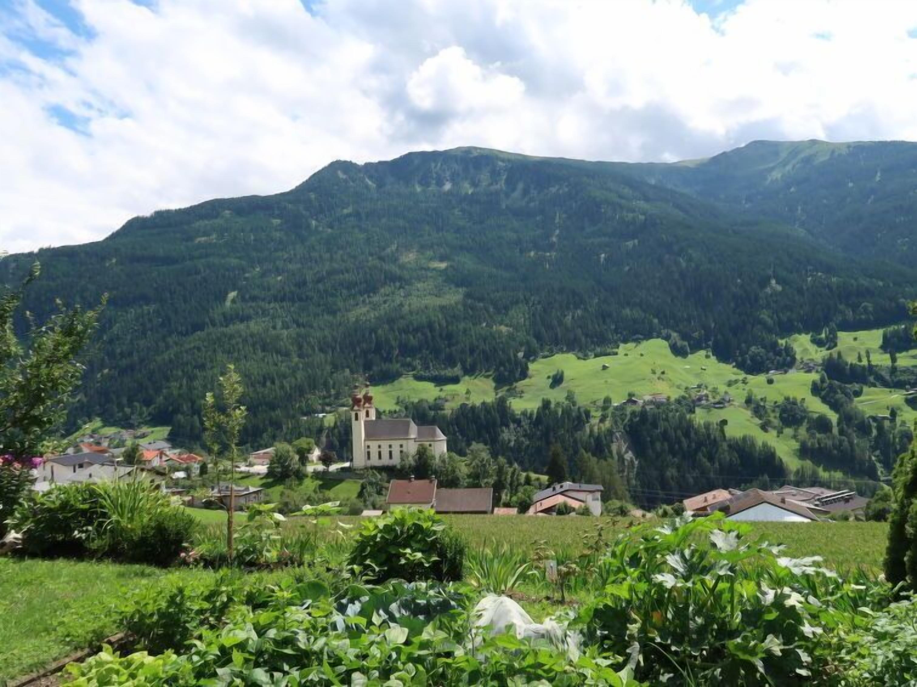 A mountainous landscape with a church and residential buildings.