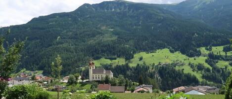 A mountainous landscape with a church and residential buildings.
