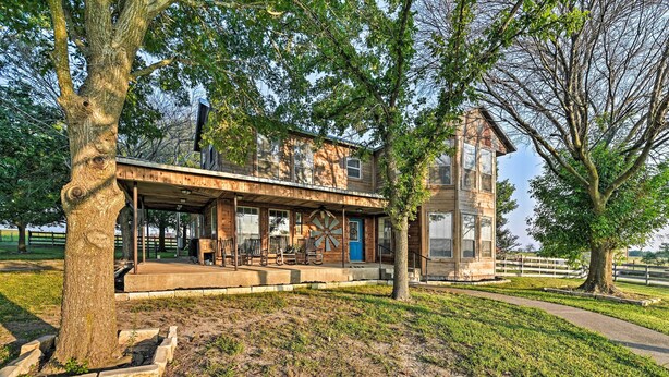 A rustic wooden building with a covered porch and a large tree in front. - Charming Hamilton Farmhouse w/ Country Views! (Gustine)