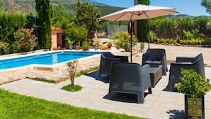 Un espace aménagé au bord de la piscine, avec des meubles d’extérieur et une pergola.