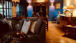 Un salon chaleureux avec un plafond en briques, un canapé agrémenté de coussins, une table basse sur laquelle repose un vase décoratif et une cheminée.