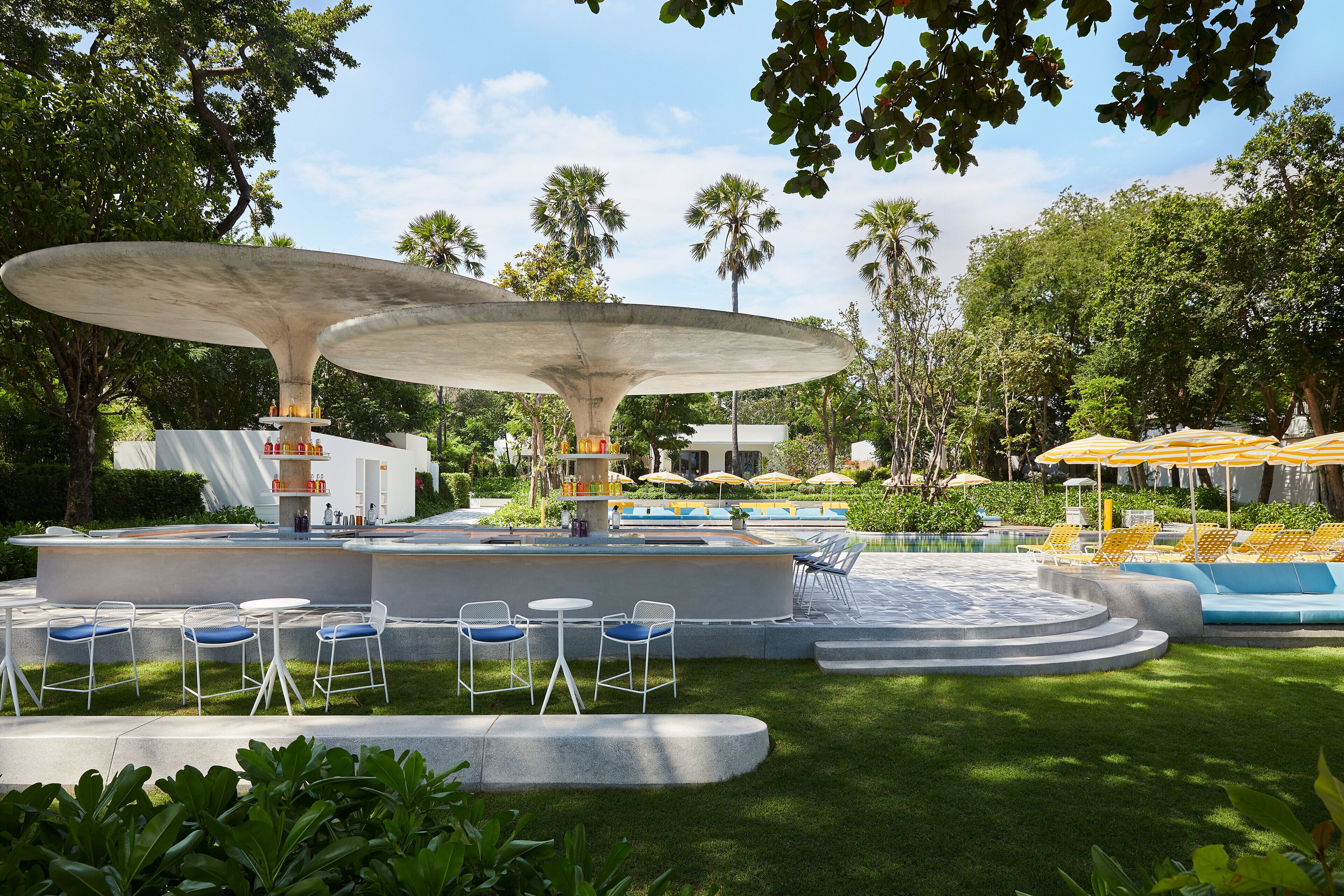 An outdoor pool area with a bar, seating, and umbrellas.