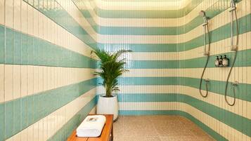 A small, tiled room with a bench and a potted plant.