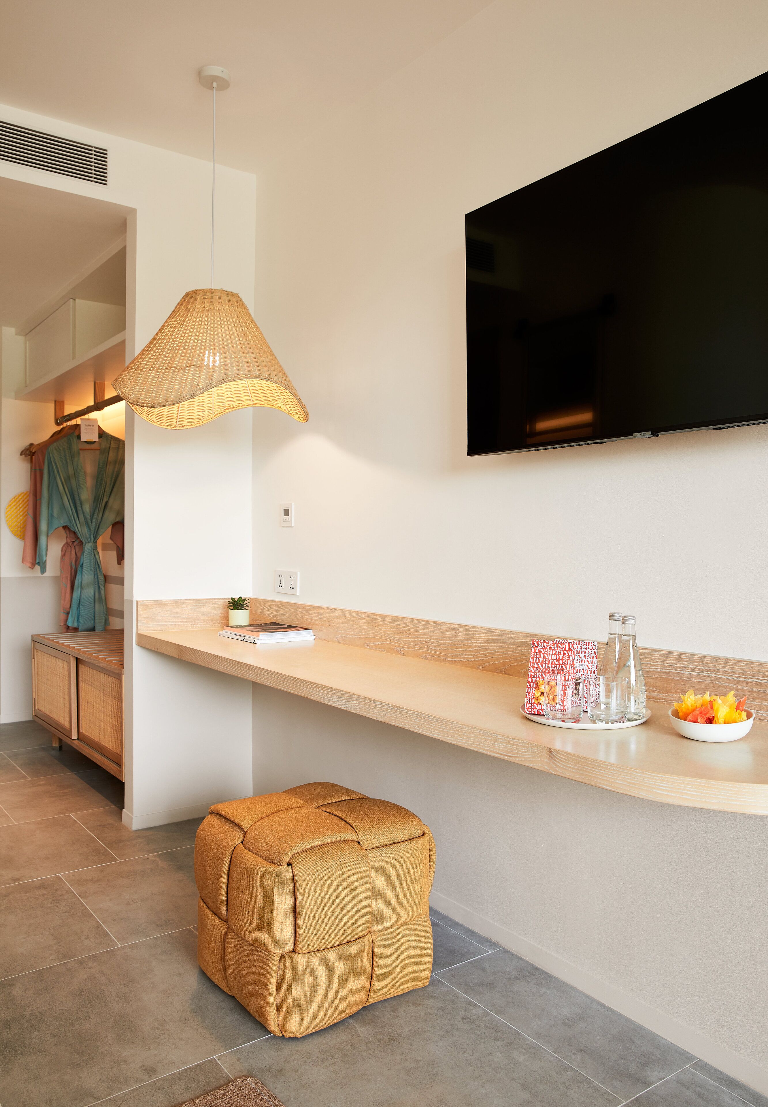 Una cocina moderna con encimera de madera, lámpara colgante y televisor de pantalla plana montado en la pared.