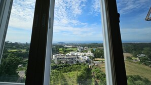 A view through a window with a clear sky and a distant landscape. - Haemil Resort (Jeju City)