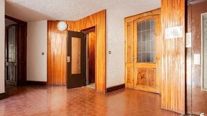 A hallway with wooden paneling, a tiled floor, and a door with a frosted glass window. - ❤️🏔 The Lantern in the Mountains ❤️🏔 (Pragelato-Ruà TO)