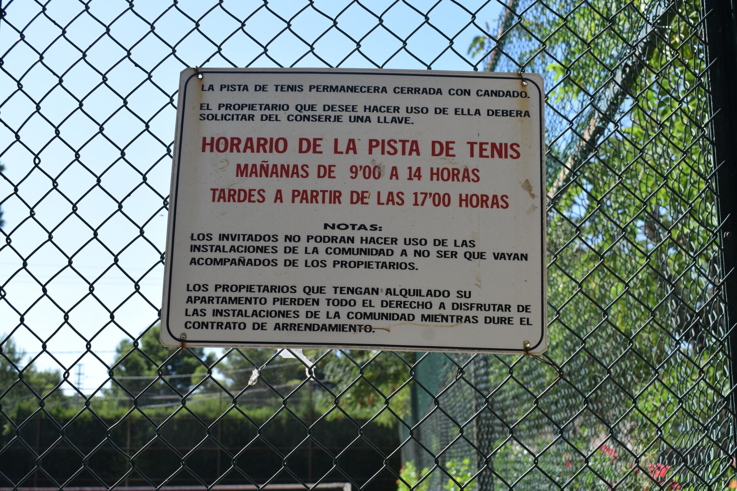 A chain-link fence with a sign attached to it.