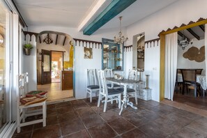 Un coin repas avec une table ronde, des chaises blanches et un lustre.
