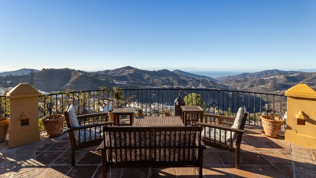 A terrace with a wooden bench, potted plants, and a view of distant hills. - Villa "madre tierra pool jacuzzi" with Mountain View, Pool, Whirlpool (Cómpeta)