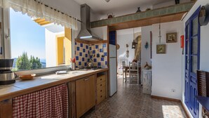 Una cocina con un ventanal amplio, una estufa y un fregadero.