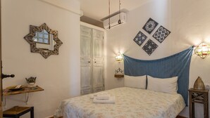 Un dormitorio con cama, escritorio, silla, armario y decoración en la pared.
