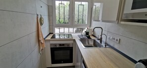 A modern kitchen with a dishwasher, sink, and window.