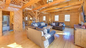 Un intérieur de chalet en bois spacieux, doté d’un grand espace de vie, de nombreux coins salon et d’une cuisine.