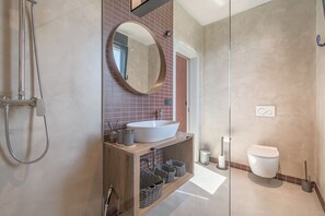 Regadera, secadora de cabello, toallas, papel de baño 
