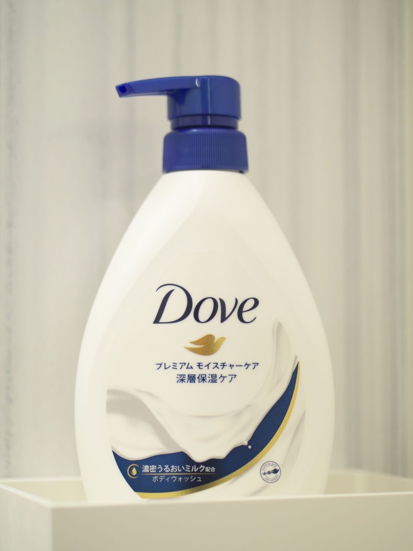 A Dove personal care product bottle with a pump dispenser, placed on a white surface.