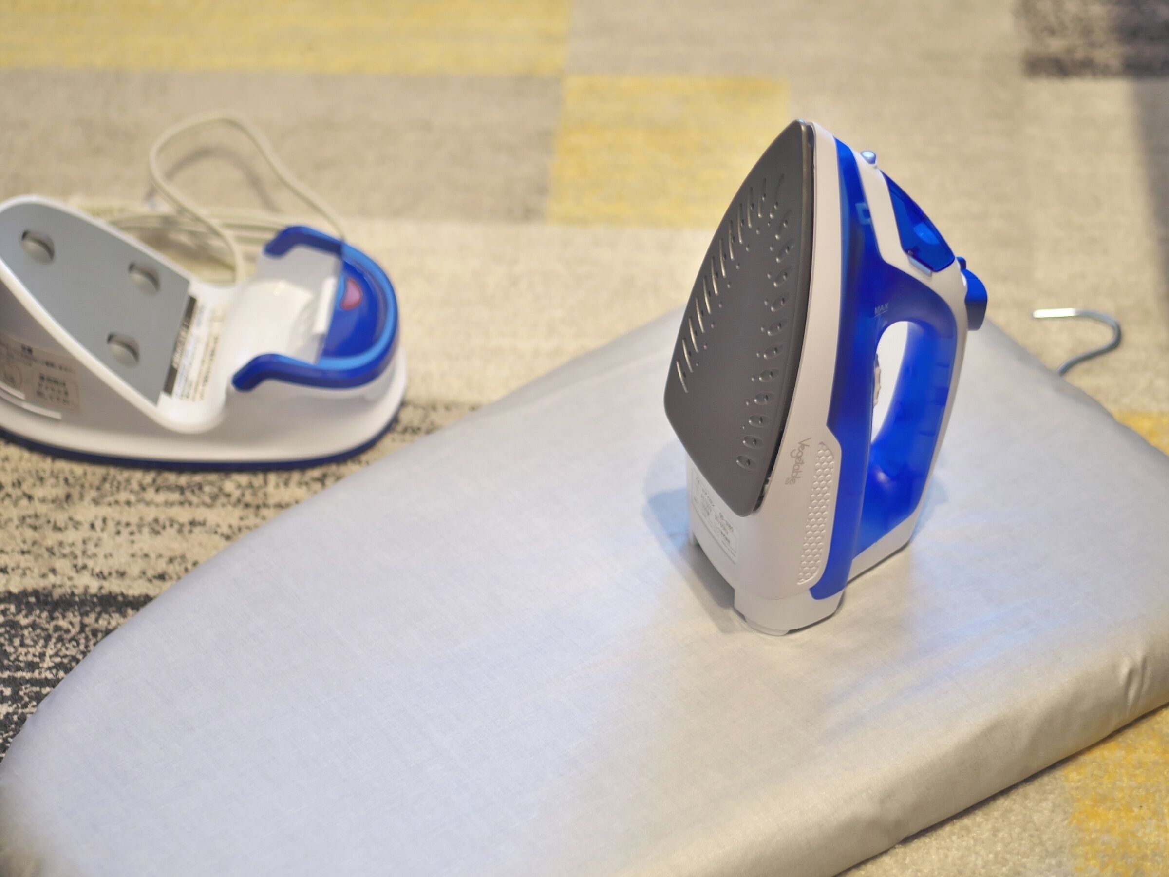 Un plancha y un pinza para la ropa sobre una superficie plana.