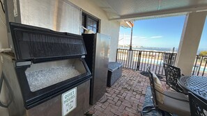 A balcony with a view of the ocean, a quiet hours sign, and outdoor seating. - Vista Marquesa  4/3 Ground Level Home w/ Pool & 50` Dock (Marathon)