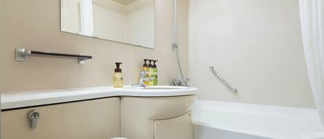 Un baño con inodoro, lavabo, espejo, ducha y toallero.