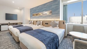 Une chambre d’hôtel avec deux lits, un bureau, une chaise et une grande fenêtre donnant sur un beau paysage.