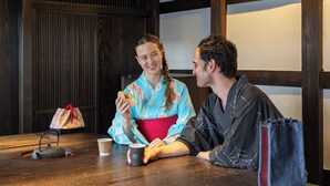Une table en bois avec une théière, deux tasses et un sac.