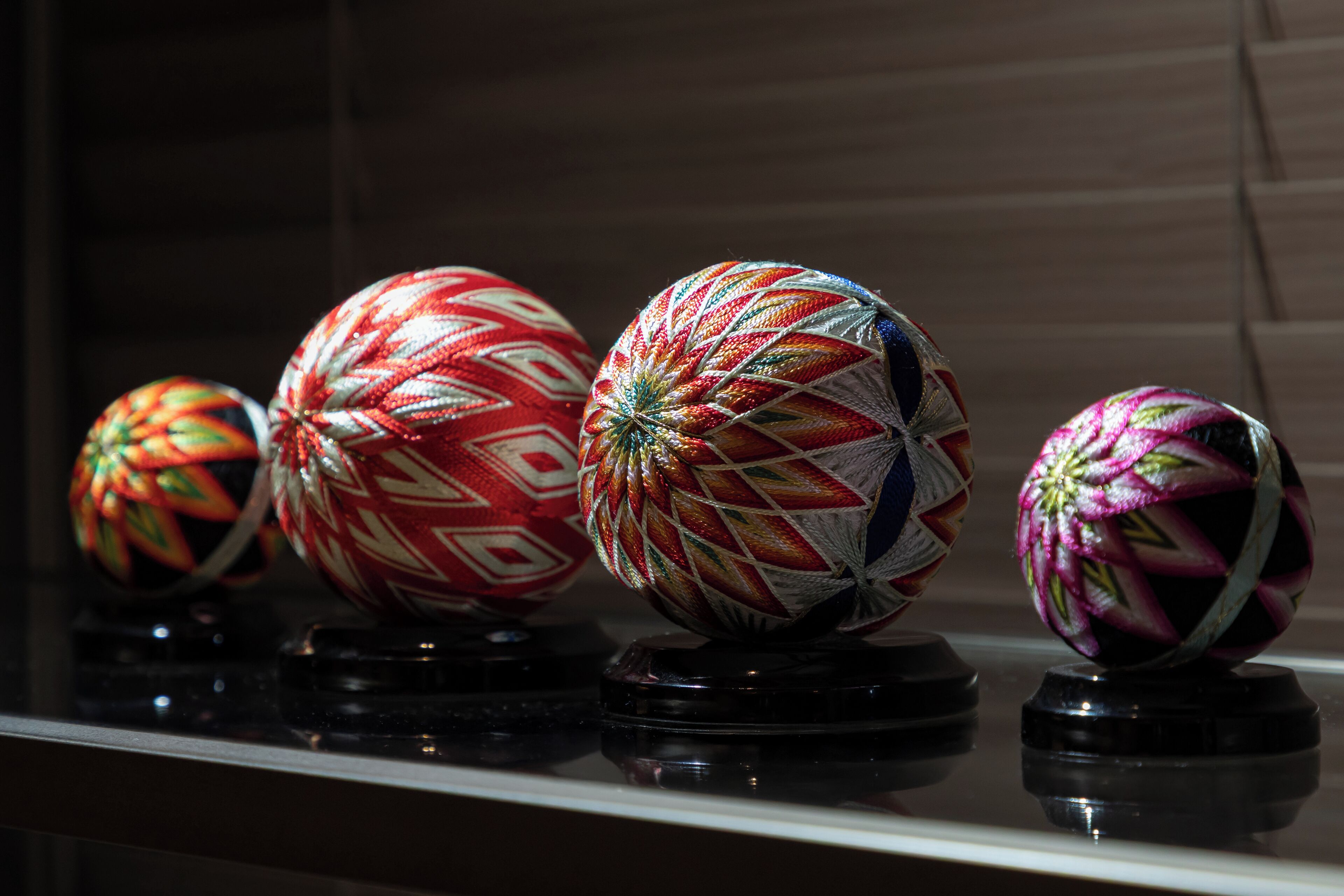 A collection of spherical objects with intricate patterns, displayed on stands.