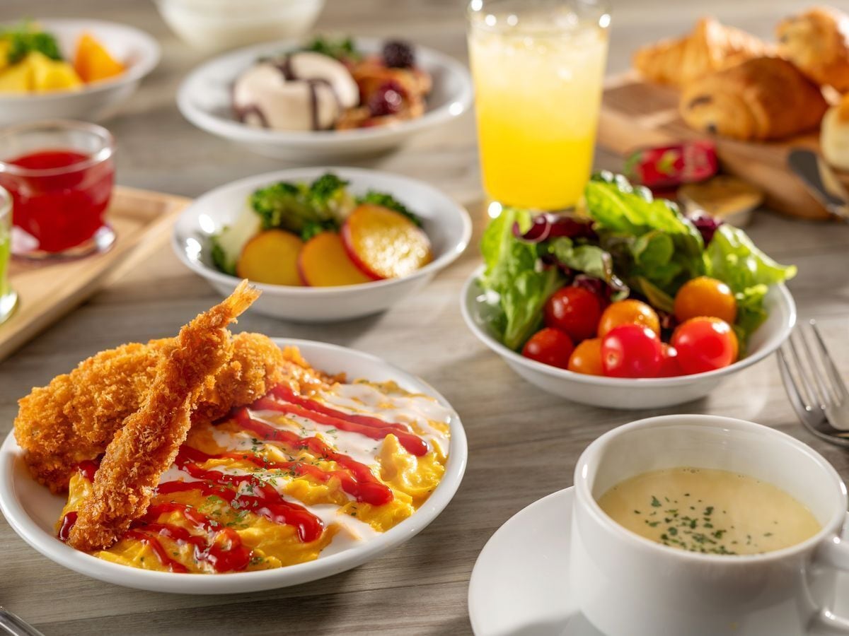 A breakfast setting with various dishes including fried chicken, eggs, and salads.