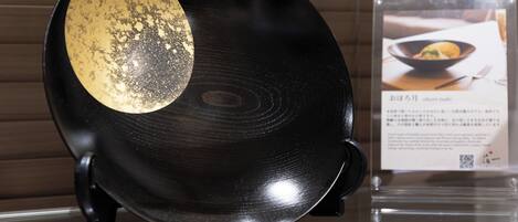 Un disco de vinilo con etiqueta, exhibido sobre un soporte con un letrero al fondo.