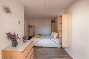Une chambre à coucher avec un lit, une table de chevet et une armoire.