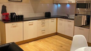 A modern kitchen with white cabinets, a black countertop, and stainless steel appliances. - Apartment - Sleeps 4 - Balcony - Parking - Pets Ok (Hull)