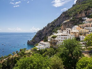 A coastal village with white buildings nestled against a cliff, overlooking the sea. - Casa Lauro (Positano)