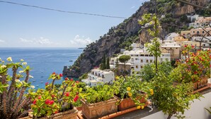 A coastal village with white buildings, a cliff, and the sea. - Casa Lauro (Positano)
