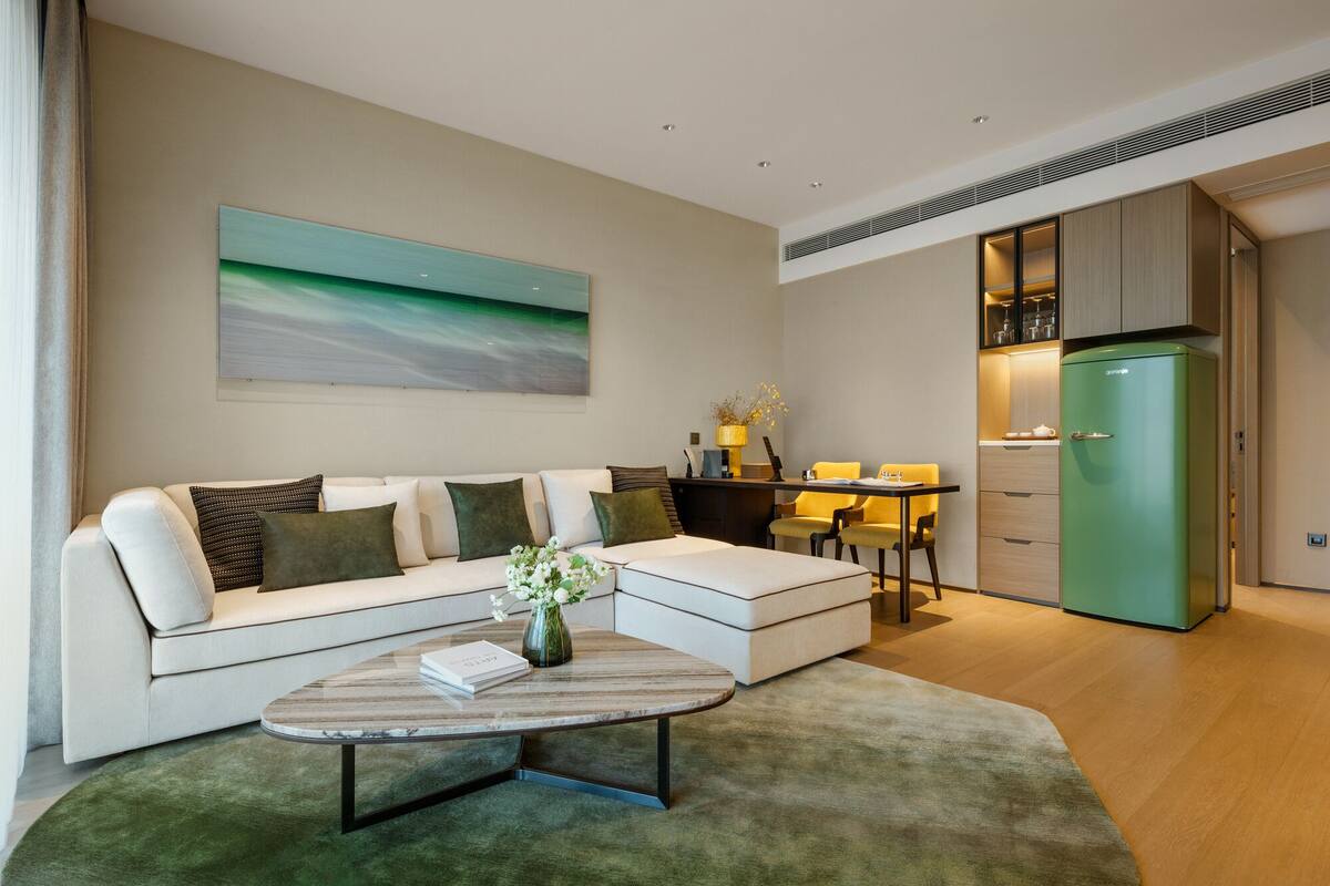 A modern living room with a sofa, coffee table, and a painting on the wall.