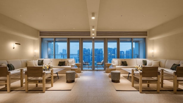 Amplia sala de estar con dos sofás orientados hacia una ventana grande que ofrece vistas de la ciudad.