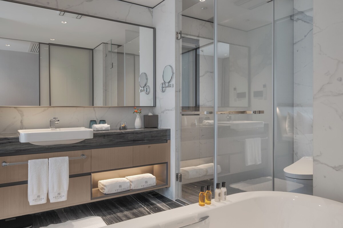 Un baño moderno con una bañera grande, un tocador con espejo y una cabina de ducha de vidrio.
