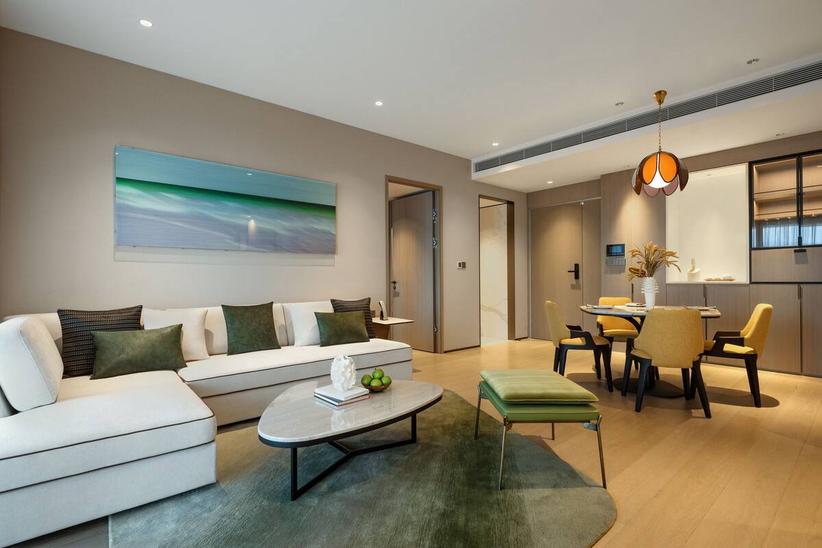 A modern living room with a sofa, coffee table, and dining area.